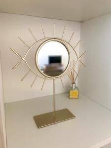 a gold sun mirror on a wall in a room at Surčin Apartment in Ledine