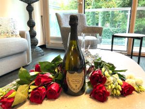 a bottle of wine sitting on a table with roses at Grand Apartment Sissi in Trieste