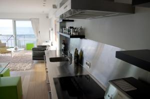 a kitchen with a sink and a counter with bottles at The Lighthouse in Koksijde