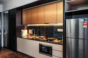 a large kitchen with a stainless steel refrigerator at Scarletz Suites KLCC by Mana-Mana in Kuala Lumpur