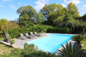 a swimming pool with lounge chairs and a swimming pool at Gîte LA FORESTERIE in Ladignac-le-Long