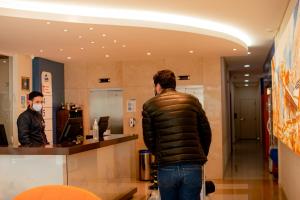 a man standing at a counter in a store at Luds Comfort Hotel in Ponta Grossa