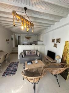 un soggiorno con divano e tavolo di Myconian Avra Apartment a Megali Ammos