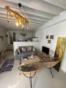 ein Wohnzimmer mit einem Sofa und einem Tisch in der Unterkunft Myconian Avra Apartment in Megali Ammos