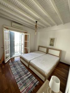a bedroom with a bed and a large window at Myconian Avra Apartment in Megali Ammos