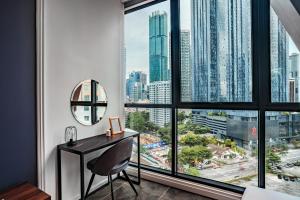 a desk in a room with a large window at Scarletz Suites KLCC by Mana-Mana in Kuala Lumpur