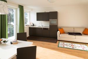 cocina y sala de estar con sofá y mesa en Ramsau Appartements Pickl, en Ramsau am Dachstein