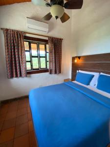 Hotel Beyonda في سانتا مارتا: غرفة نوم بسرير ازرق مع مروحة سقف