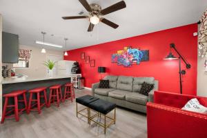 sala de estar con paredes rojas, sofá y bar en HEIRS LIVING : BEAUX - Near Cabrini Hospital . Colleges . 3TVs . Free Parking . Pet Friendly . 2BR Fully Furnished, en Pineville
