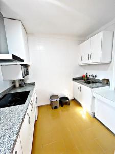 a kitchen with white cabinets and a yellow floor at AMR El Palmeral in Mojácar
