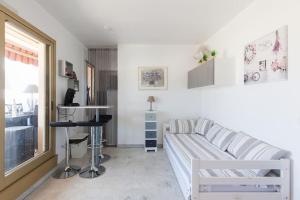 un soggiorno con divano e tavolo di Studio vue mer panoramique sur la baie de Cannes a Le Cannet