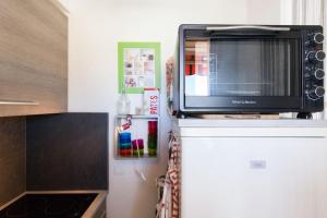 un forno a microonde seduto sopra un frigorifero di Studio vue mer panoramique sur la baie de Cannes a Le Cannet