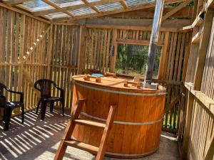 a large wooden tub in a screened in porch at Cabañas Campestres Villarrica in Villarrica