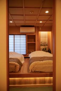 2 camas en una habitación con ventana en 巡, en Osaka