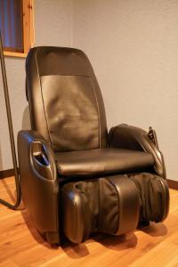 une chaise en cuir noir assise au-dessus du parquet dans l'établissement 巡, à Osaka