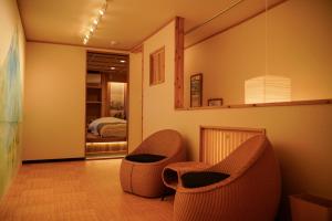 1 dormitorio y sala de estar con 2 sillas. en 巡, en Osaka