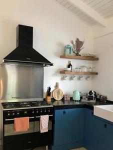 a kitchen with a black stove and a sink at Villa Perla due (diving villa Chikitu) in Kralendijk