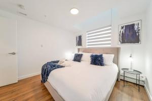 a white bedroom with a large white bed and a table at Royal Blue Wild Oasis Corner PNHSE KingBed U/G Wi-fi in Edmonton +49 photos