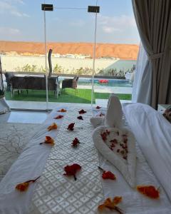a bed with flowers on it with a view of a beach at alsaif camp in Badīyah