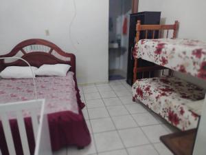 a small room with a bed and a chair at Apartamento aconchegante in Guaratinguetá