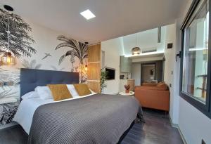 1 dormitorio con 1 cama grande y 1 sofá en Plasencia Plaza Mayor Luxury, en Plasencia