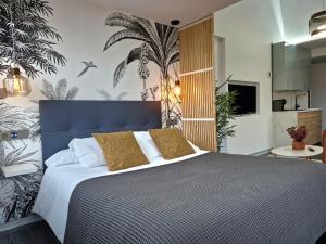 a bedroom with a large bed with white sheets and yellow pillows at Plasencia Plaza Mayor Luxury in Plasencia