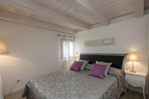 ein Schlafzimmer mit einem großen Bett mit lila Kissen in der Unterkunft Residenza Tiziano in Venedig