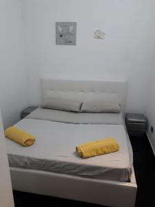 een bed met twee gele kussens erop bij Casa Balestrate in Balestrate