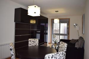 a dining room with a black table and chairs at Apartamento centro Villagarcía. in Vilagarcia de Arousa