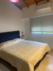 a bedroom with a bed with a blue headboard and a window at Depto en Monte Grande a 15 minutos del Aeropuerto 2 Zona Residencial in Monte Grande