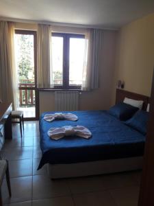 a bedroom with a bed with two towels on it at Apartment 322, Villa Park in Borovets