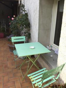 a green table and two chairs on a patio at Appartement complet entre Disney et Paris a 15 minutes de la cite universitaire in Champs-sur-Marne