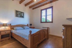 1 dormitorio con cama de madera y ventana en Le balcon du Cagire, 