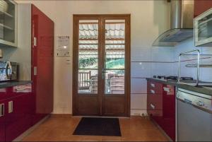 a kitchen with a wooden door and a window at Le balcon du Cagire 
