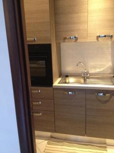 a kitchen with wooden cabinets and a sink at Via Roma suite in Ortona