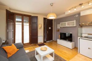 sala de estar con sofá azul y TV en Casa benito en el corazón del casco histórico garaje incluido, en Zamora