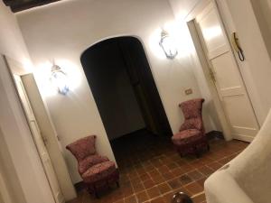 a hallway with two chairs and a mirror at La Tenuta di Leo in San Giovanni in Persiceto