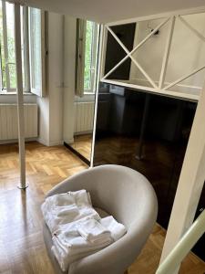 Ponte Milvio Smart Appartamento في روما: كرسي أبيض في غرفة مع مرآة