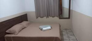 a bed with a mirror and a pillow on it at Pousada Bela Rainha in Aparecida