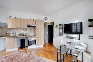 a living room with a table and a kitchen at CMG Solidarite 5 in Montreuil