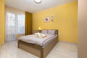 a bedroom with a large bed with yellow walls at Lovely 1BD Apartment next to University of Plovdiv in Plovdiv