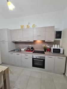 uma cozinha com armários brancos e um forno com placa de fogão em Curti Granda em Rescaldina