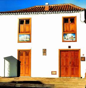 a white house with two wooden doors on it at Casa SotoMayor in Santiago del Teide