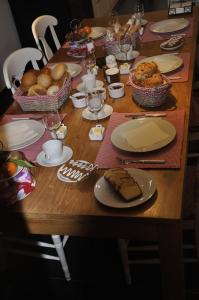 una mesa de madera con platos de comida. en B&B Pierre-Marie en Bovekerke