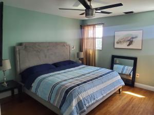1 dormitorio con 1 cama y ventilador de techo en KL Retreat 6BR-4BTH with Jacuzzi and family room! en Key Largo