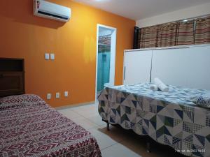 アハイアウ・ド・カボにあるVista Maravilhosa da Praia Grandeのベッドルーム(ベッド1台、テレビ付)