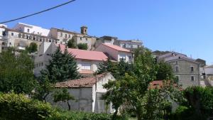 un grupo de edificios en una colina con árboles en Residenza Sulla Roccia, en Bovino