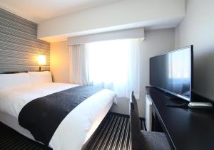 東京にあるアパホテル〈新宿御苑前〉のベッド1台、薄型テレビが備わるホテルルームです。