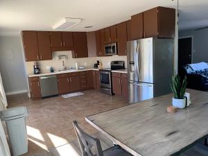 a kitchen with wooden cabinets and a table and a refrigerator at Sapphire Lake House* Boat Parking for 2 + Backyard in Page