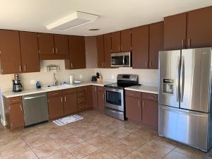 a kitchen with wooden cabinets and stainless steel appliances at Sapphire Lake House* Boat Parking for 2 + Backyard in Page